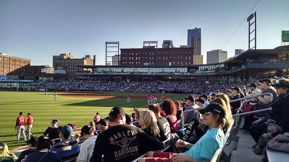 Packed stands at CHS Field on Opening Day for the Saint Paul Saints, with the green playing field and Lowertown skyline visible beyond the outfield