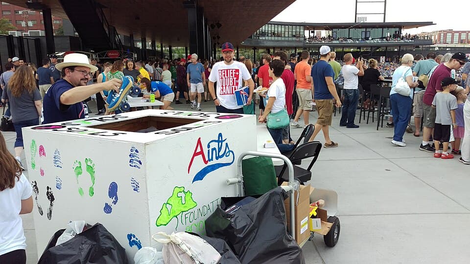 Volunteers organizing donated shoes at a community shoe drive held at CHS Field, the Saints' ballpark in Lowertown Saint Paul