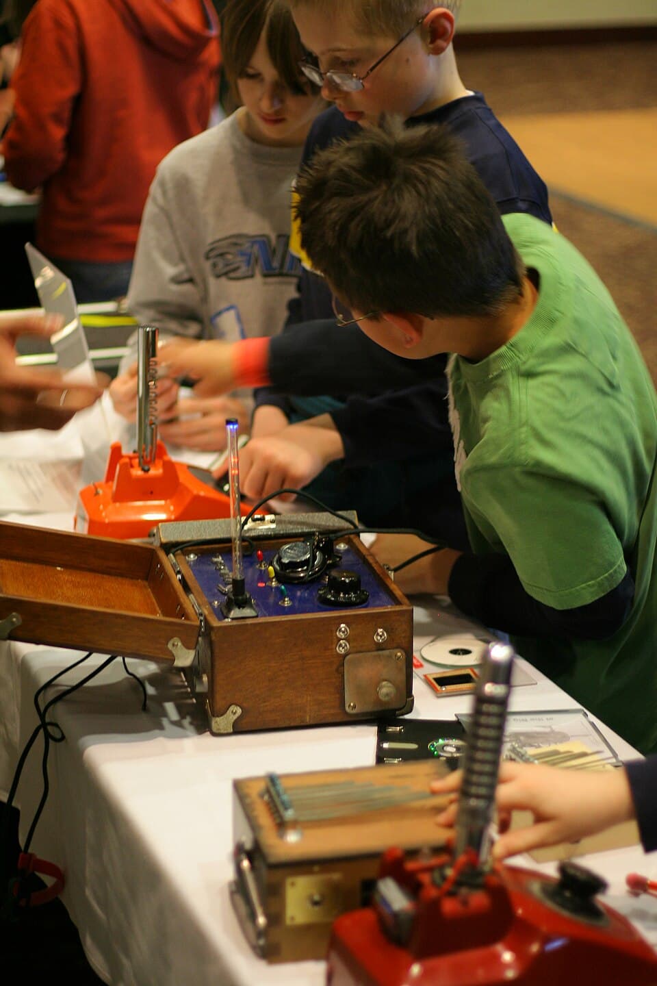 Children crowding around Tim Kaiser's handmade electronic musical instruments at Make Day inside the Science Museum of Minnesota